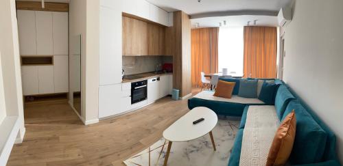 a living room with a blue couch and a kitchen at Star Apartament Gjiri lalzit, Lura 2 in Lalzit Bay