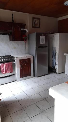 a kitchen with stainless steel appliances and brown cabinets at Managua Backpackers Inn in Managua