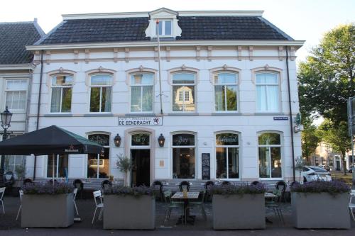 a white building with tables and chairs in front of it at Boutique Hotel Weesp in Weesp