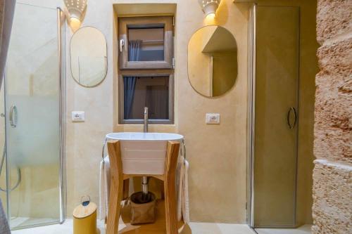 a bathroom with a sink and a shower with mirrors at Corte Janca in Montesano Salentino