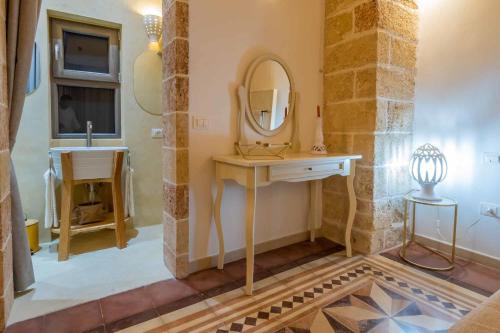 a bathroom with a sink and a mirror at Corte Janca in Montesano Salentino
