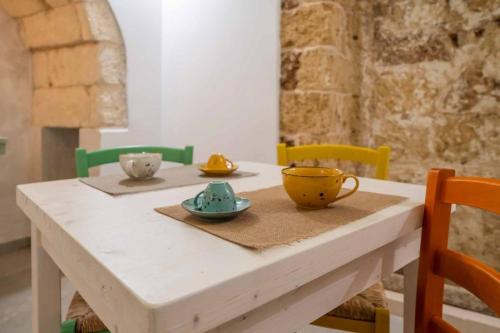 a wooden table with two cups and bowls on it at Corte Janca in Montesano Salentino