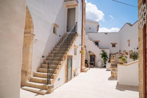 a street with white buildings and stairs at Corte Janca in Montesano Salentino