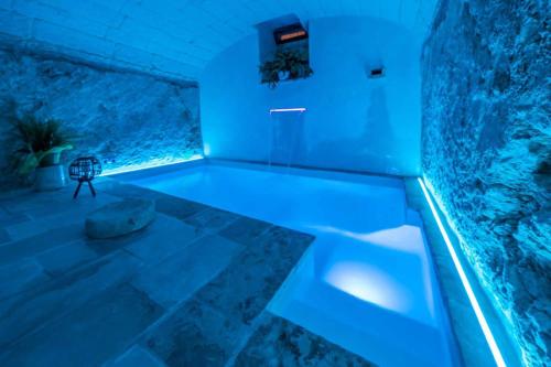 a bath tub with blue lighting in a room at Corte Janca in Montesano Salentino