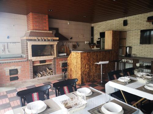 uma cozinha com lareira de tijolos e mesas e cadeiras em Гостевой дом Discovery em Almaty