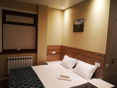um quarto com uma cama com duas almofadas em Гостевой дом Discovery em Almaty