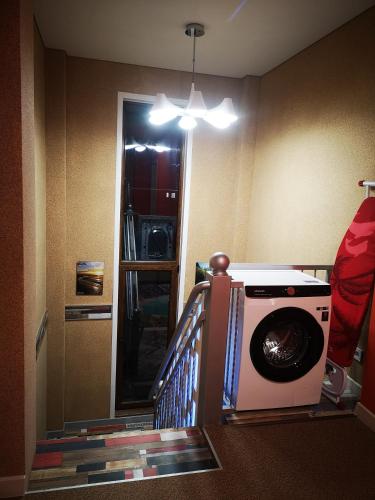 a washing machine in a room with a staircase at Гостевой дом Discovery in Almaty