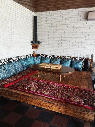 a couch with a table on top of a rug at Гостевой дом Discovery in Almaty