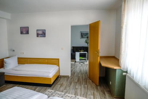 a bedroom with a bed and a desk in it at Pension Bergstube in Bad Langensalza