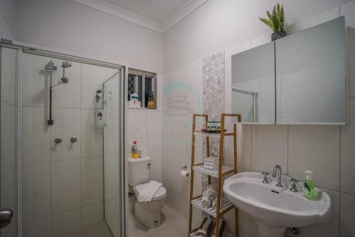 a bathroom with a shower and a sink and a toilet at ZEN HIDEAWAY COZY 2-BR/2-BA Modern Unit in Alawa in Casuarina