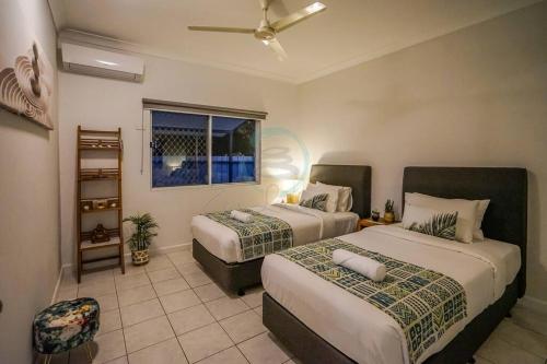 a bedroom with two beds and a window at ZEN HIDEAWAY COZY 2-BR/2-BA Modern Unit in Alawa in Casuarina