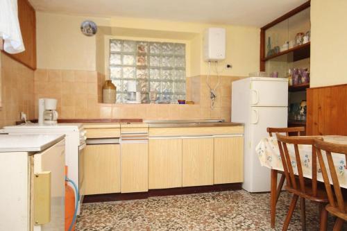 een keuken met houten kasten en een witte koelkast bij Rooms with a parking space Lumbarda, Korcula - 9299 in Lumbarda
