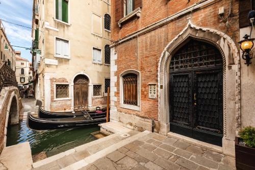 a canal between two buildings with a gondola at San Zaccaria Apartment in Venice