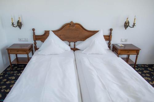 two beds in a room with two night stands at Landhaus Hotel Neuss in Neuss