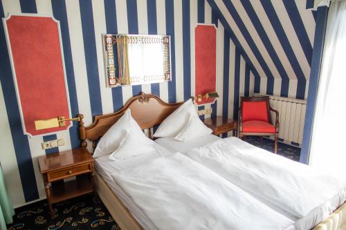 a bed in a room with blue and white stripes at Landhaus Hotel Neuss in Neuss