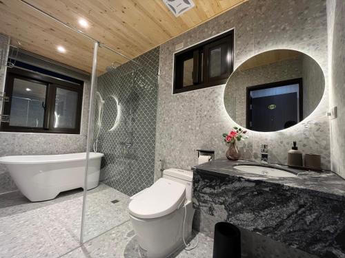 a bathroom with a toilet and a sink and a mirror at Lin House in Checheng