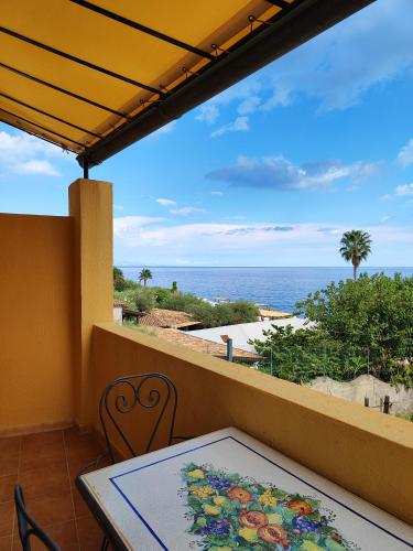 a balcony with a table and a view of the ocean at Torre dei Pirati in Letojanni