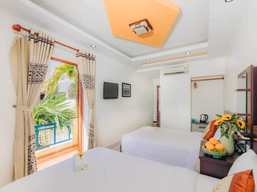 1 dormitorio con 2 camas y ventana en Botanic Garden Villas, en Hoi An
