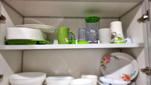 a shelf with cups and dishes on it at شقة مطلة على البحر والفورمولا in Jeddah