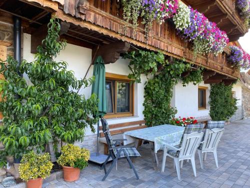 a table and chairs in front of a building with flowers at Ferienwohnung Schiestl in Zell am Ziller