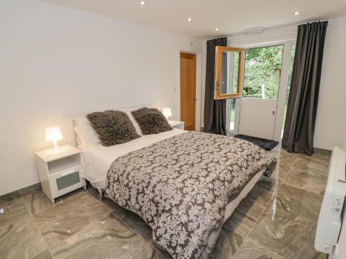 a bedroom with a large bed and a window at Hollywell Cottage in Lichfield