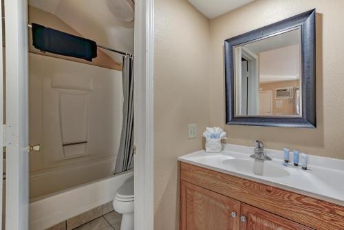 a bathroom with a sink and a toilet and a mirror at Shasta Pines Motel & Suites in Burney