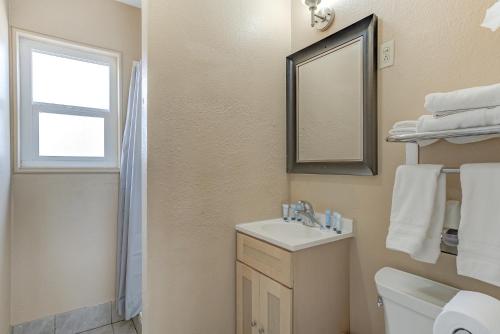 a bathroom with a sink and a toilet and a window at Shasta Pines Motel & Suites in Burney