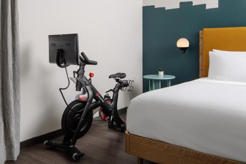 a hotel room with an exercise bike next to a bed at Origin Austin, a Wyndham Hotel in Austin