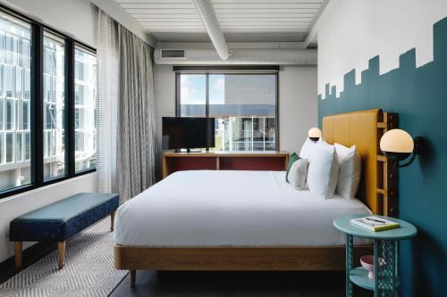 a hotel room with a bed and a tv at Origin Austin, a Wyndham Hotel in Austin