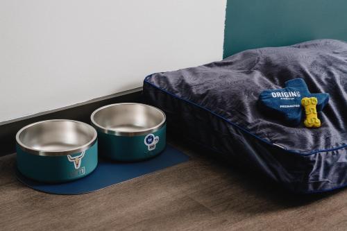 two metal buckets sitting on the floor next to a bed at Origin Austin, a Wyndham Hotel in Austin