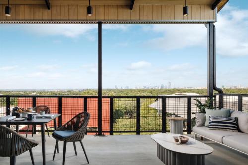 a living room with a couch and a table and chairs at Origin Austin, a Wyndham Hotel in Austin