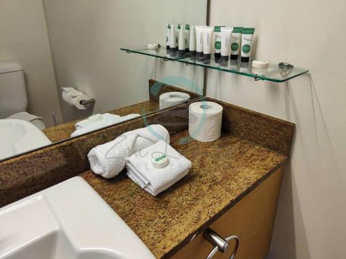 baño con lavabo y encimera con toallas en ZEN88 ESPLANADE: 1-BR Top Floor Ocean View Suite, en Darwin
