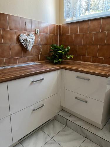 a kitchen with white cabinets and brown tiles at UBYTOVÁNÍ ALENA in Ostrava