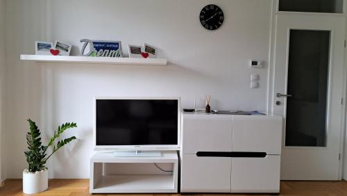 a living room with a tv on a white cabinet at Apartman Dreams in Lukavica
