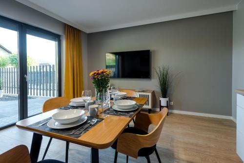 a dining room with a wooden table and chairs at Apartament Widok 1 in Piechowice