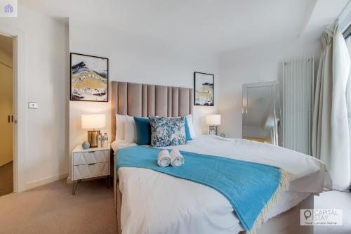 a bedroom with a large bed with two towels on it at Luxury Three bed Apartment by London ExCeL in London
