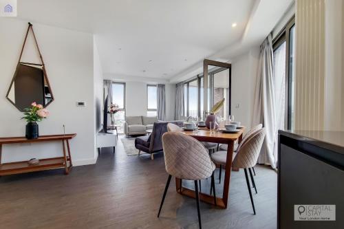 a living room with a table and chairs at Luxury Three bed Apartment by London ExCeL in London