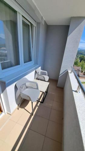 a balcony with two chairs and a table and a window at Apartman Dreams in Lukavica
