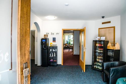 a hallway with a room with a refrigerator and a table at Pension Bergstube in Bad Langensalza