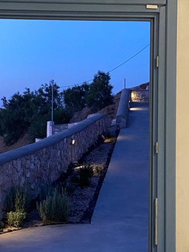 a view through a window of a stone wall at ENA suites Santorini in Pirgos