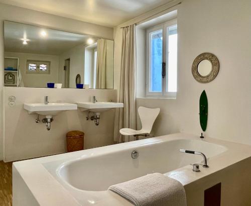 a white bathroom with a tub and two sinks at kirchgässlein in Dinkelsbühl