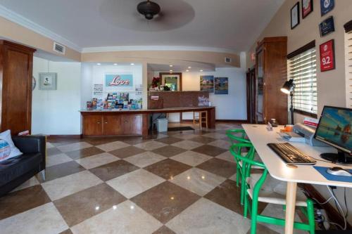 a living room with a desk with a computer on it at Victoria Park Hotel in Fort Lauderdale