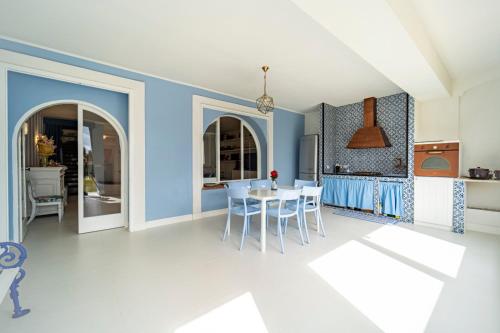 a kitchen and dining room with blue walls and a table and chairs at Casa Azzurra in Messina