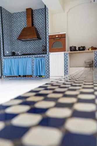 a kitchen with blue and white tiles on the wall at Casa Azzurra in Messina