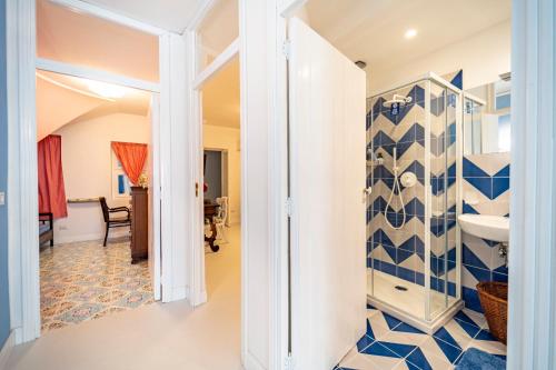 a bathroom with a blue and white tiled wall at Casa Azzurra in Messina