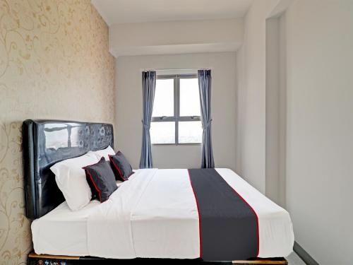 Schlafzimmer mit einem großen Bett und einem Fenster in der Unterkunft OYO Capital O 91631 M-square Apartement in Bandung