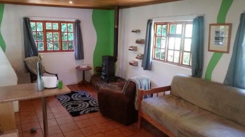 a living room with green and white walls at Gryffin Cottage at Hogwarts Forest in Hogsback