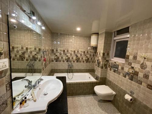 a bathroom with a sink and a tub and a toilet at THE IMPERIAL HOTEL & Spa in Gangtok