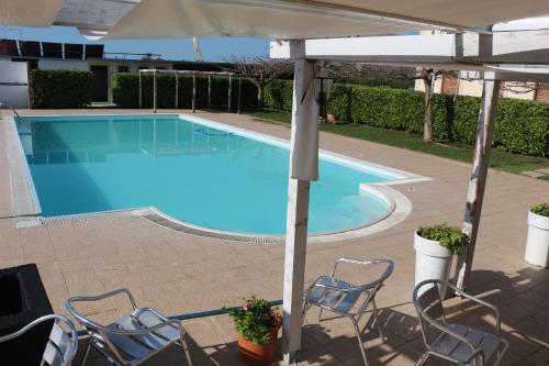 a swimming pool with chairs and an umbrella at Aranceto Hotel Agriturismo in Arenella