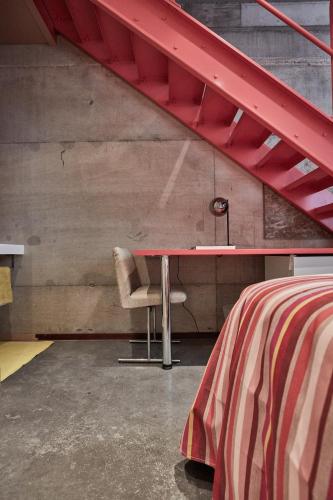 a red table and a chair in a room at LA PORTE ROUGE RBX in Roubaix